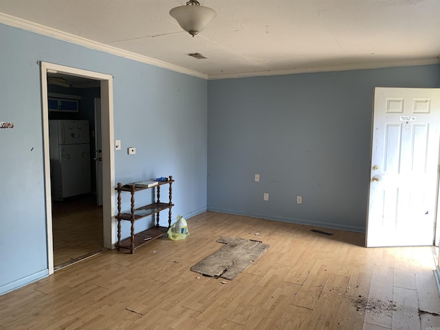 unfurnished room with crown molding and light hardwood / wood-style flooring