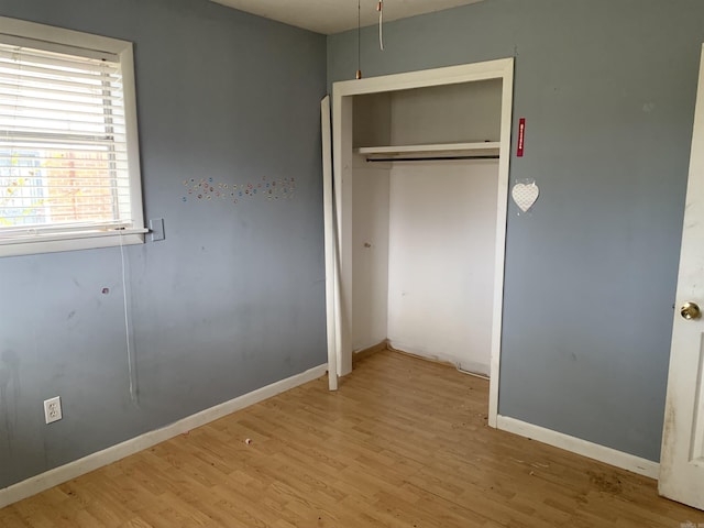 unfurnished bedroom featuring light wood-type flooring and a closet