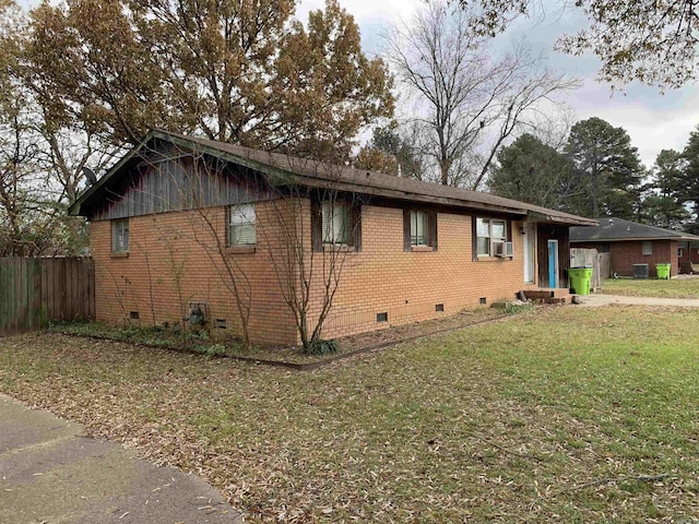 view of side of home with cooling unit and a yard