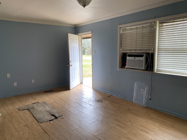 empty room with light hardwood / wood-style floors, cooling unit, and crown molding