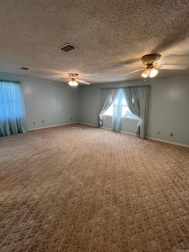 carpeted empty room featuring ceiling fan and a textured ceiling