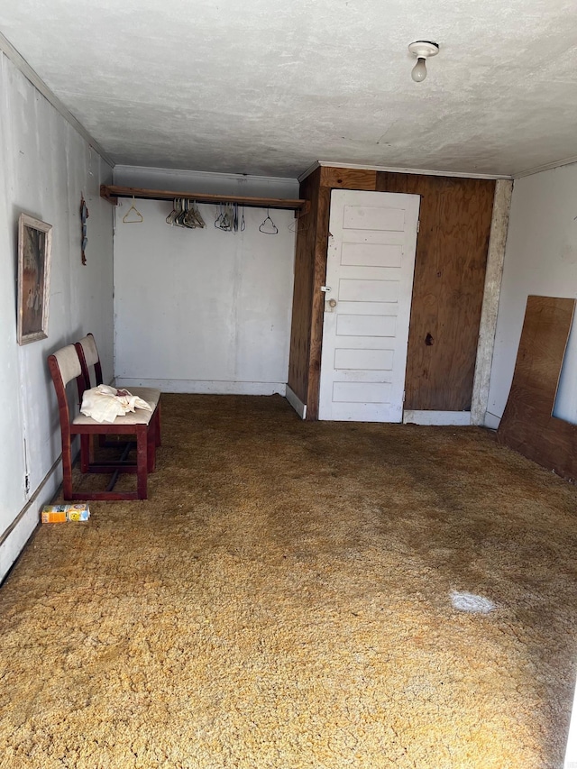 unfurnished room with a textured ceiling and wood walls