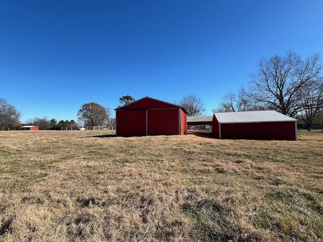 view of yard with a rural view and an outbuilding