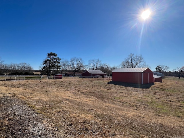 view of yard featuring a rural view and an outdoor structure