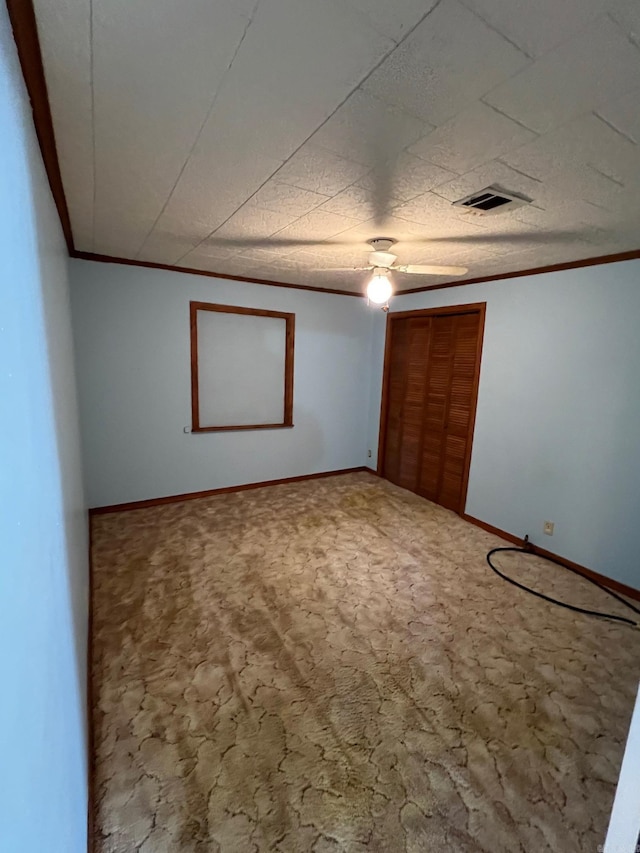 unfurnished bedroom featuring carpet floors, ceiling fan, and crown molding