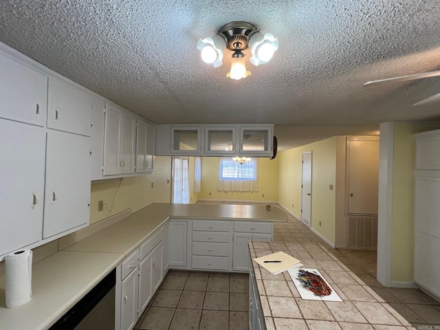 kitchen featuring a textured ceiling, white cabinetry, kitchen peninsula, and light tile patterned floors