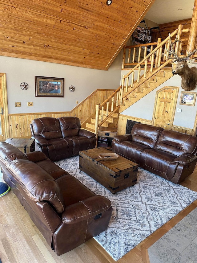 living room with wood walls, wood-type flooring, lofted ceiling, and wood ceiling