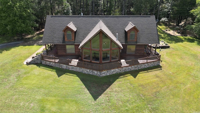 back of property with a wooden deck, a sunroom, and a lawn