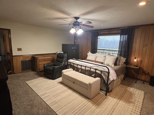 carpeted bedroom with ceiling fan and wooden walls