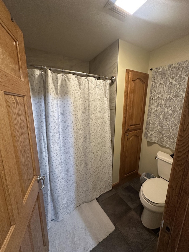 bathroom with toilet and a shower with shower curtain