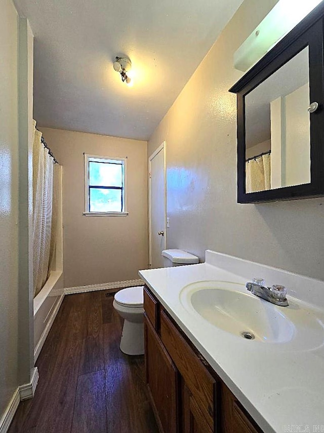 full bathroom featuring hardwood / wood-style floors, vanity, toilet, and shower / bath combo