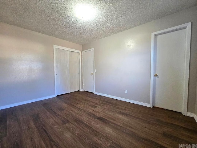 spare room with dark wood-type flooring and a textured ceiling