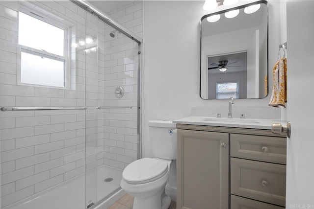 bathroom with vanity, tile patterned flooring, ceiling fan, toilet, and a shower with shower door