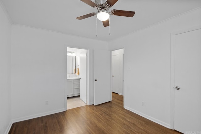 unfurnished bedroom with ceiling fan, light hardwood / wood-style floors, crown molding, and ensuite bath