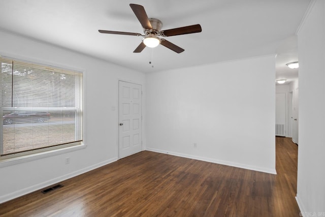 unfurnished room with ceiling fan, crown molding, and dark wood-type flooring