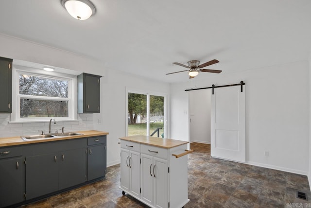 kitchen featuring plenty of natural light, a barn door, sink, and wooden counters