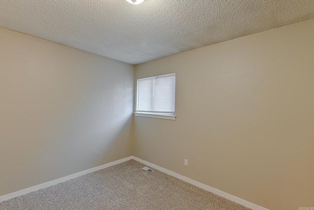 spare room featuring carpet and a textured ceiling