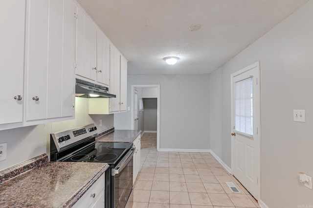 kitchen featuring dark stone counters, stainless steel electric range oven, a textured ceiling, light tile patterned floors, and white cabinetry