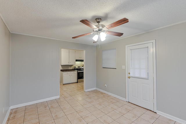 spare room featuring wood walls, ceiling fan, a textured ceiling, and ornamental molding