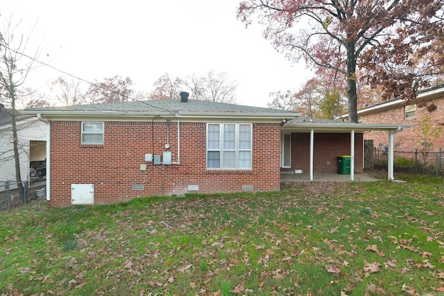 back of house with a lawn and a patio