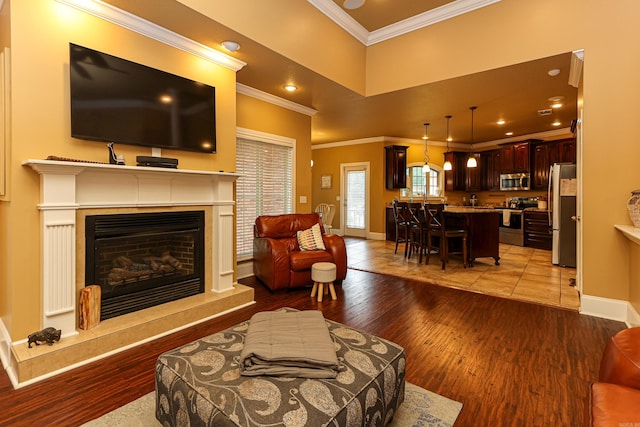 living room featuring crown molding, a high end fireplace, and light wood-type flooring