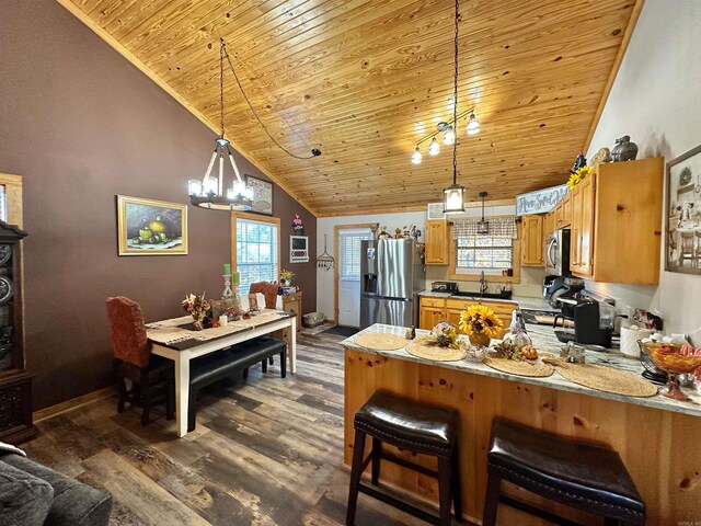 kitchen featuring hanging light fixtures, stainless steel appliances, an inviting chandelier, dark hardwood / wood-style flooring, and kitchen peninsula