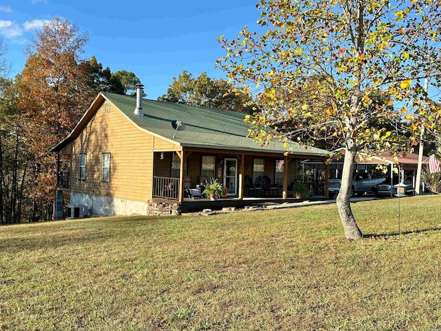 view of front of home with a porch, cooling unit, a carport, and a front lawn