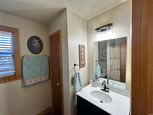 bathroom with a shower with shower curtain, vanity, and toilet