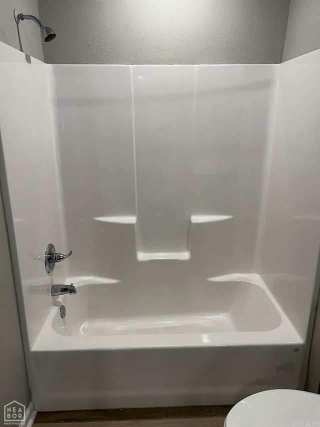 bathroom featuring toilet and washtub / shower combination