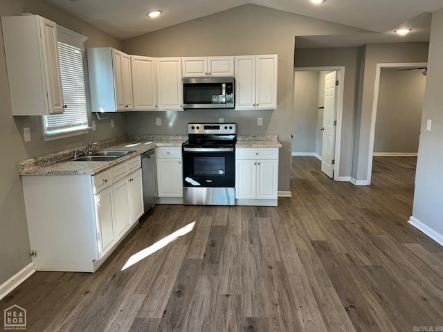 kitchen featuring white cabinets, stainless steel appliances, and vaulted ceiling