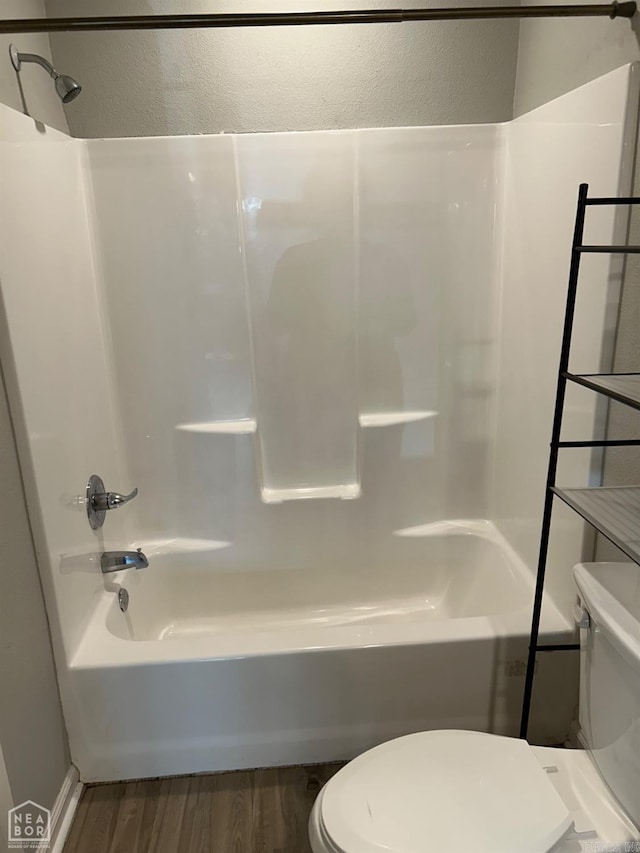bathroom with toilet, shower / washtub combination, and hardwood / wood-style flooring