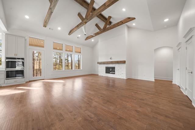 unfurnished living room featuring hardwood / wood-style floors, a fireplace, high vaulted ceiling, and beamed ceiling