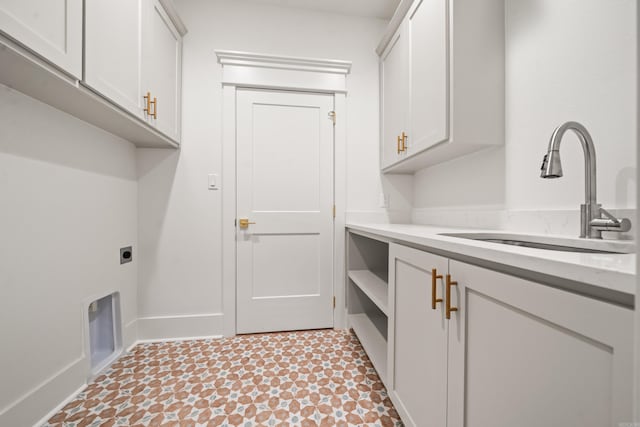 washroom with electric dryer hookup, sink, and cabinets