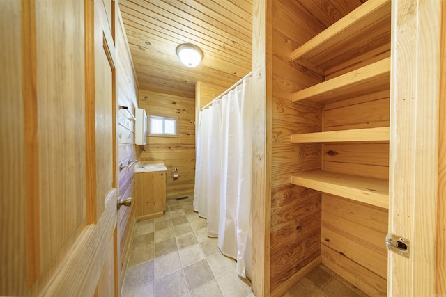 bathroom featuring wooden walls and wood ceiling