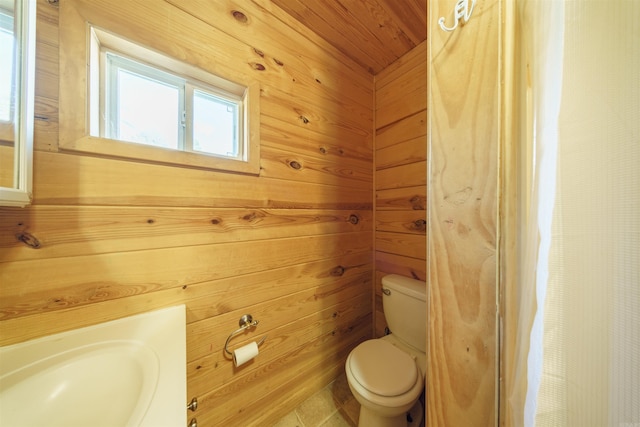 bathroom with toilet, wooden walls, and wood ceiling