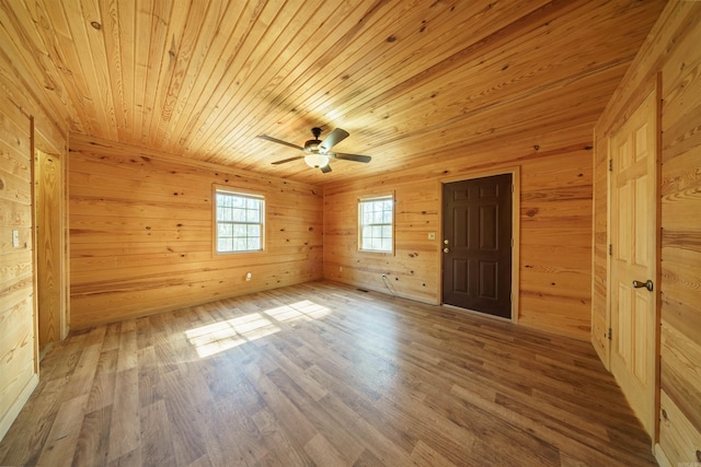 spare room with wood walls, hardwood / wood-style floors, ceiling fan, and wooden ceiling