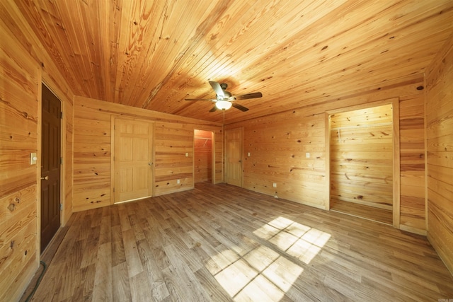 interior space featuring ceiling fan, wood walls, light wood-type flooring, and wooden ceiling