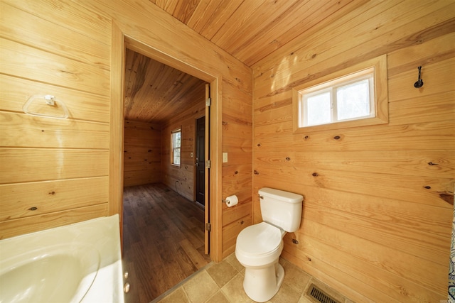 bathroom with toilet, wooden ceiling, and wooden walls