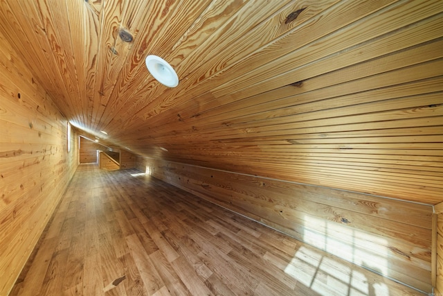 bonus room with wood walls, wooden ceiling, and wood-type flooring