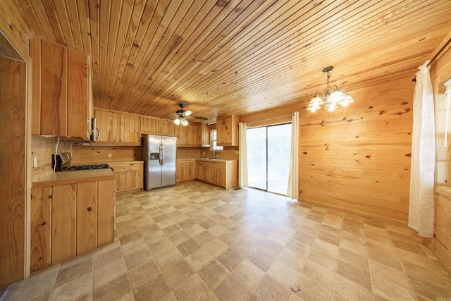 kitchen featuring wood walls, wood ceiling, hanging light fixtures, and appliances with stainless steel finishes