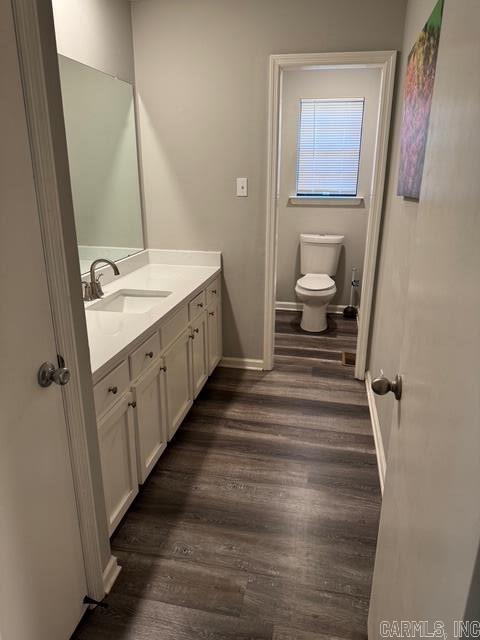 bathroom with vanity, wood-type flooring, and toilet