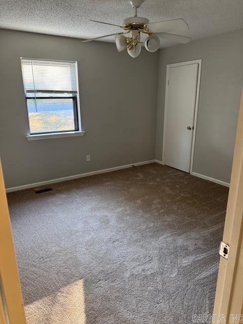 spare room with carpet flooring, a textured ceiling, and ceiling fan