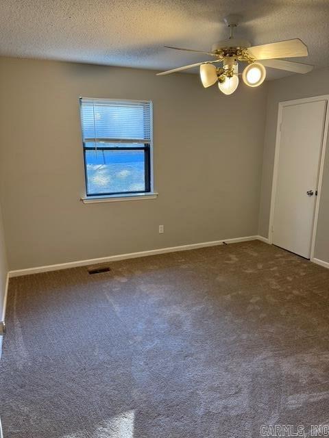 carpeted empty room featuring a textured ceiling and ceiling fan