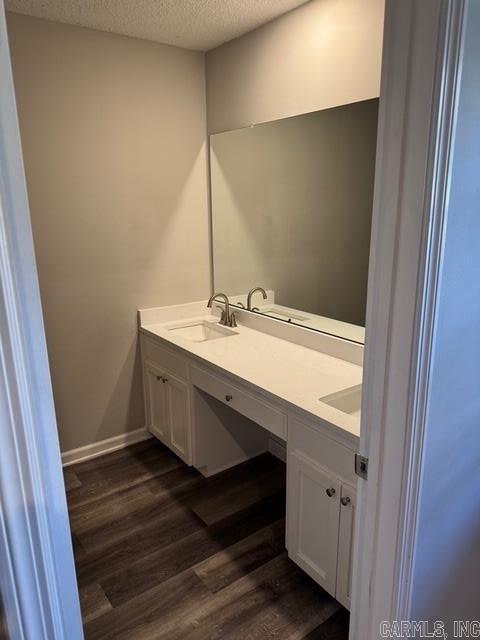 bathroom featuring hardwood / wood-style flooring, vanity, and a textured ceiling