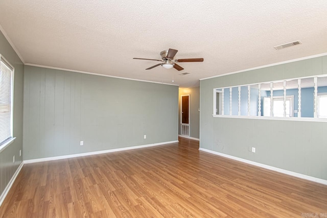 unfurnished room with ceiling fan, wood-type flooring, a textured ceiling, and ornamental molding