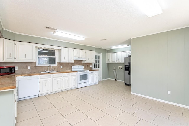 kitchen with tasteful backsplash, ornamental molding, white appliances, sink, and white cabinets