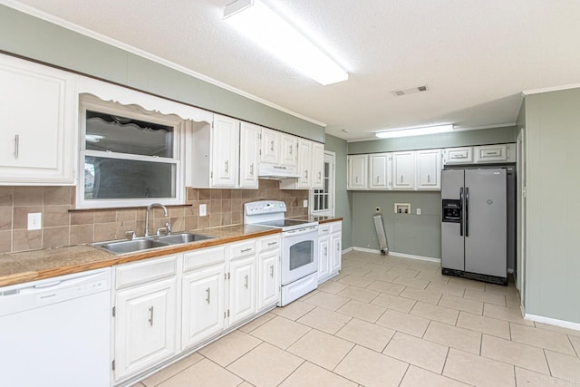 kitchen with white appliances, tasteful backsplash, white cabinetry, and sink