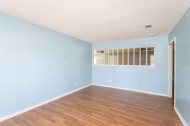 spare room with hardwood / wood-style floors and a textured ceiling