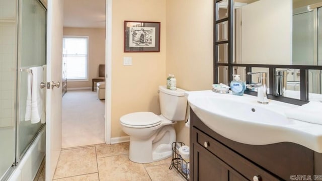 full bathroom with tile patterned floors, vanity, combined bath / shower with glass door, and toilet