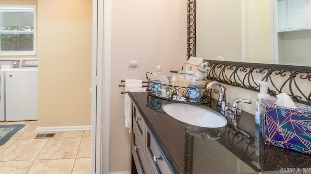 bathroom with independent washer and dryer, vanity, and tile patterned floors